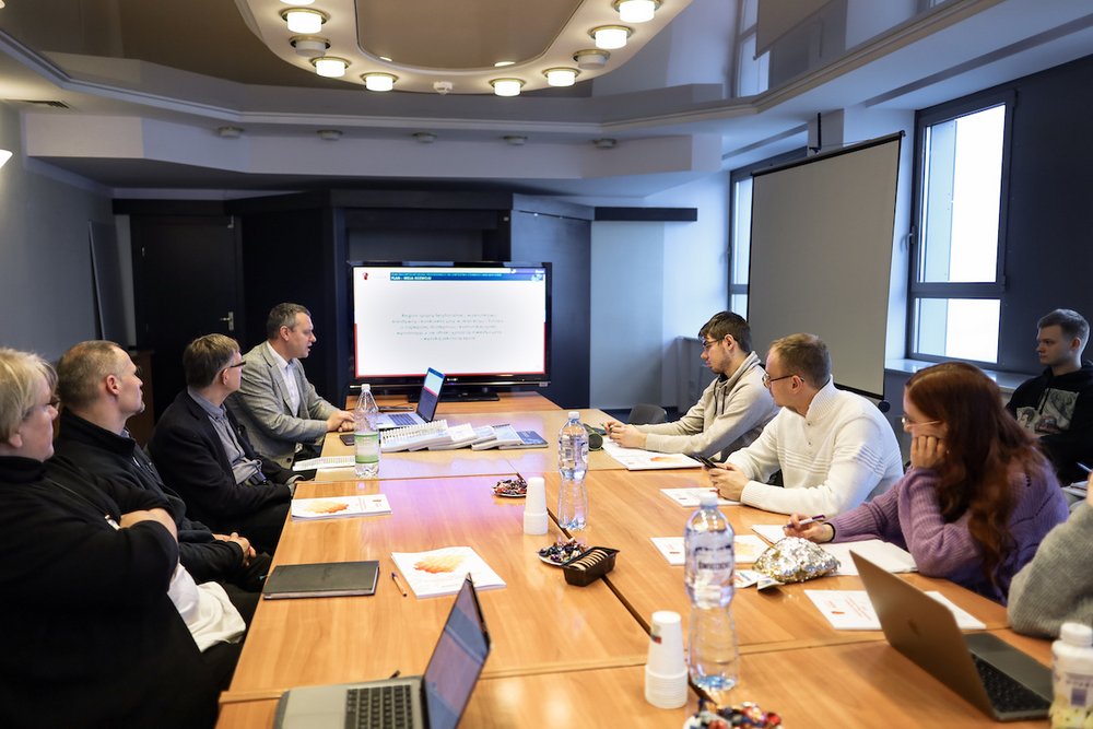 Osoby dyskutujące przy dużym stole