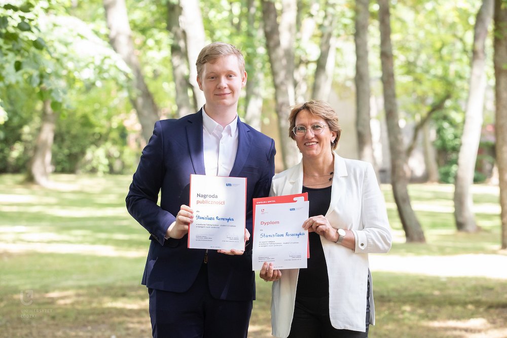 Nagrodzeni studenci pozujący do zdjęcia z dyplomami