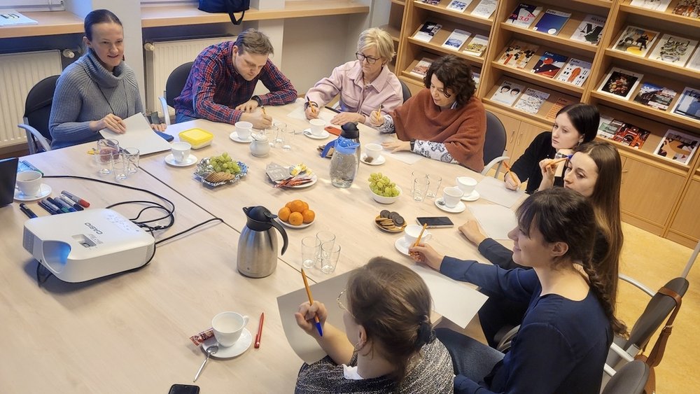 Grupa osób współpracująca ze sobą przy dużym stole