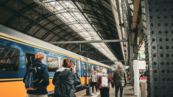 Ludzie idący na pociąg po peronie dworcowym