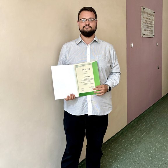 Osoba trzymająca w ręce dyplom