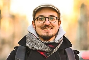 Piotr Salata-Kochanowski, brunet w okularach, z brodą, w kaszkiecie