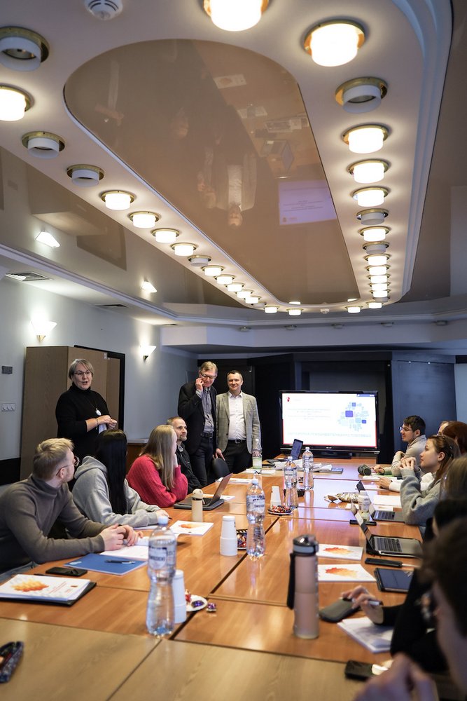 Osoby dyskutujące przy dużym stole