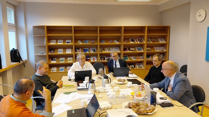 Grupa naukowców pracujących warsztatowo przy stole