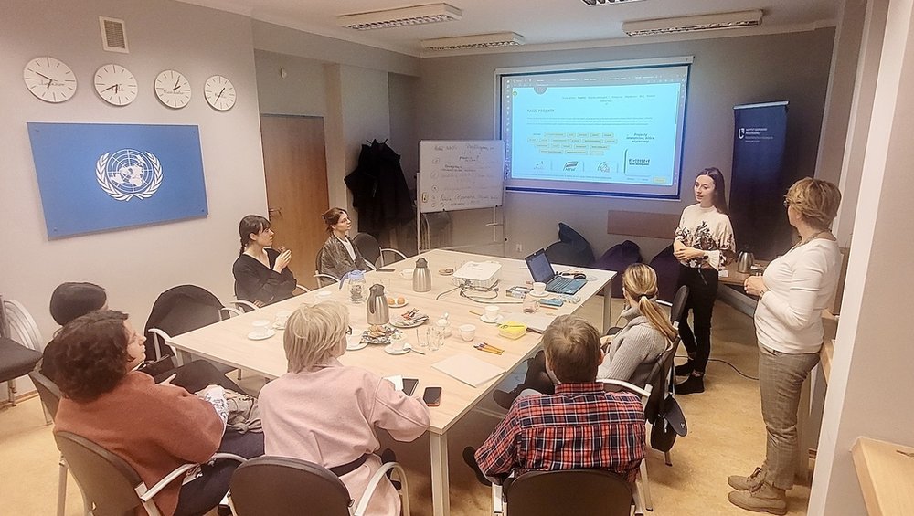 Grupa osób współpracująca ze sobą przy dużym stole