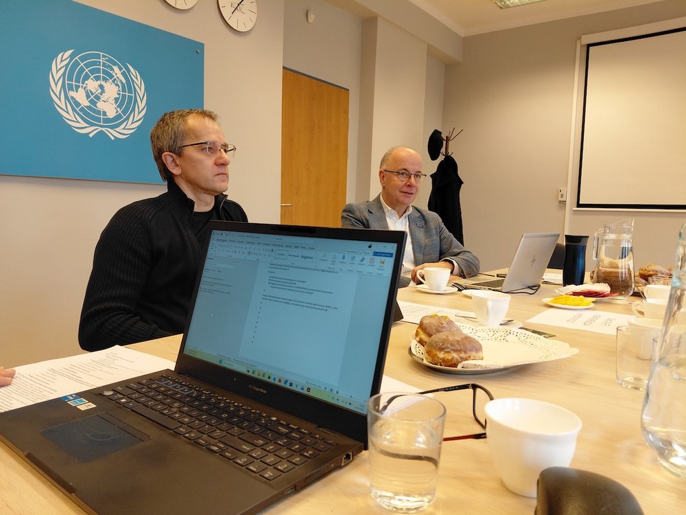 Grupa naukowców pracujących warsztatowo przy stole